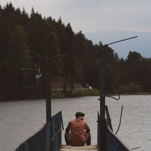 A serene person meditating outdoors surrounded by green nature.